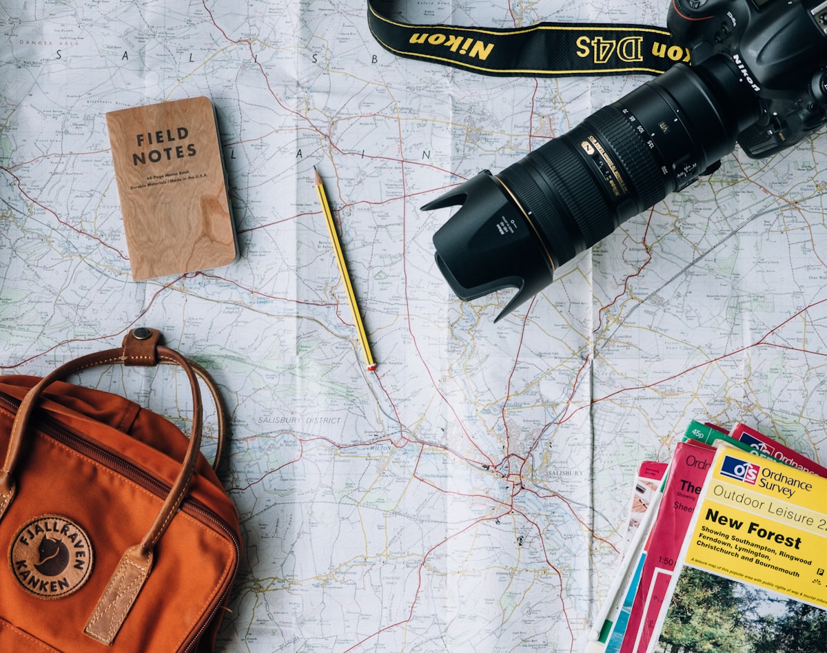 Traveler preparing gear and reviewing maps for a mountain expedition